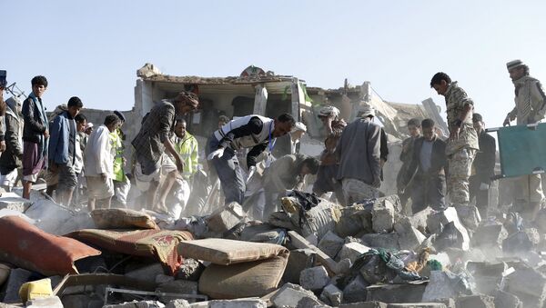 Personas desmontan las ruinas después del ataque aéreo en la capital de Yemen, Saná - Sputnik Mundo