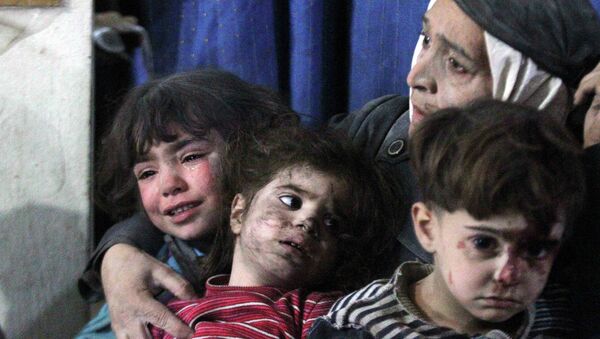 An injured woman and children react in a field hospital after what activists said were air strikes by forces loyal to Syria's President Bashar al-Assad - Sputnik Mundo