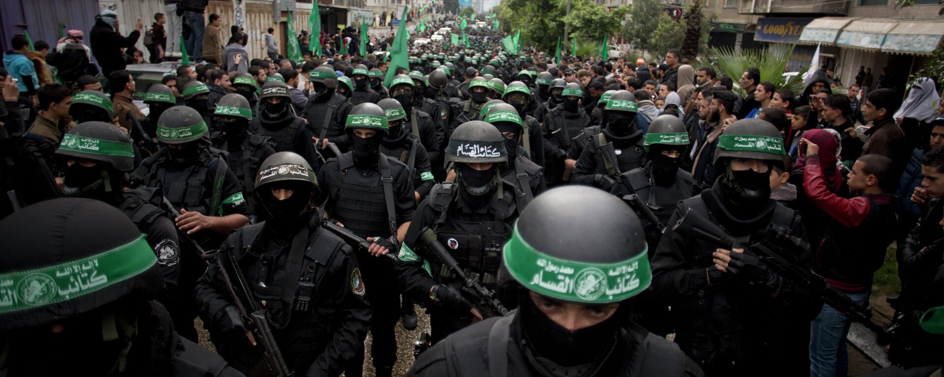 Hombres armados palestinos muestran sus habilidades militares durante una manifestación para conmemorar el 27º aniversario del grupo militante Hamas, en la ciudad de Gaza, el domingo 14 de diciembre de 2014. - Sputnik Mundo, 1920, 14.04.2024
