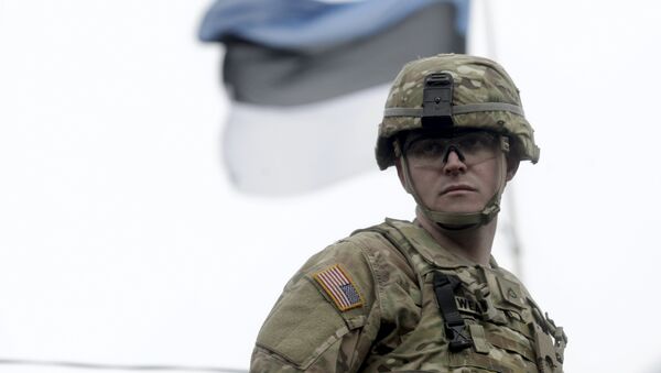 A soldier of the U.S. Army 2nd Cavalry Regiment deployed in Estonia as a part of the U.S. military's Operation Atlantic Resolve, is pictured near an Estonian flag during the Dragoon Ride exercise in Parnu March 21, 2015 - Sputnik Mundo