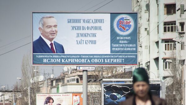 People walk in front of an election poster of Uzbekistan's President and presidential candidate Islam Karimov - Sputnik Mundo
