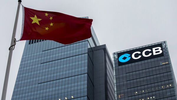 A Chinese national flag flies in front of the China Construction Bank (CCB) Tower at Hong Kong's business Central district in this December 26, 2014 file photo. - Sputnik Mundo