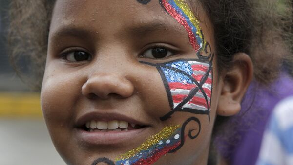 A Venezuelan girl, with her face painted with a crossed-out U.S. flag, looks on during the traditional Burning of the Judas as part of Easter celebrations in Caracas April 5, 2015. - Sputnik Mundo