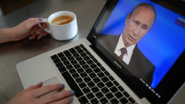 Una mujer esta viendo la emisión de la línea directa con Vladímir Putin - Sputnik Mundo