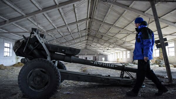An OSCE monitor inspects a cannon stored by pro-Russian rebels in the village of Novoamvrosiivske, eastern Ukraine, Friday, March 20, 2015. - Sputnik Mundo