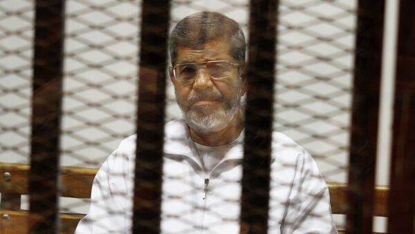 Egypt's ousted Islamist President Mohammed Morsi sits in a defendant cage in the Police Academy courthouse in Cairo, Egypt. On Tuesday April 21, 2015 - Sputnik Mundo
