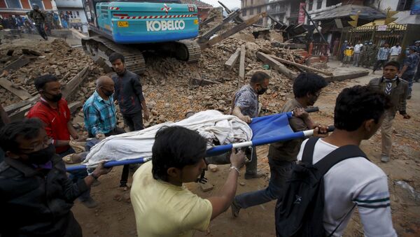 Rescue workers carry the body of a victim on a stretcher, after a 7.9 magnitude earthquake hit, in Kathmandu, Nepal - Sputnik Mundo