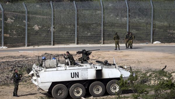 Israeli soldiers (right) and members of United Nations peacekeeping forces are seen near the frontier with Syria near Majdel Shams in the Golan Heights April 27, 2015. - Sputnik Mundo