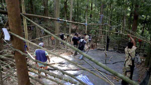 Fuerzas de seguridad y los equipos de rescate inspeccionan en el campamento abandonado en una selva en Tailandia - Sputnik Mundo