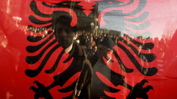 Kosovo Albanians are seen through the Albanian flag during a protest in Pristina on December 2, 2008 - Sputnik Mundo