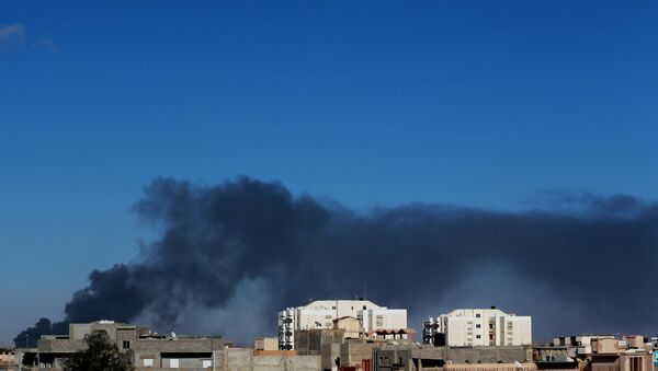 Black smoke billows in the sky above areas where clashes are taking place between pro-government forces, who are backed by the locals, and the Shura Council of Libyan Revolutionaries, an alliance of former anti-Gaddafi rebels, who have joined forces with the Islamist group Ansar al-Sharia, in Benghazi, Libya, May 18, 2015. - Sputnik Mundo
