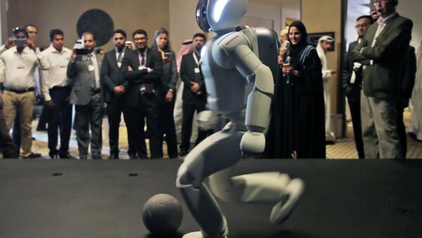 A humanoid robot designed and developed by Honda and named Asimo plays football for the audience at the end of the company's presentation during the last day of the Government Summit in Dubai, United Arab Emirates, Wednesday, Feb. 11, 2015 - Sputnik Mundo