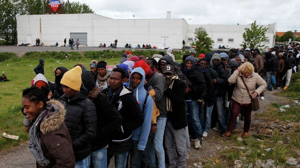 Decenas de migrantes africanos hacen cola para su comida diaria en Calais, Francia - Sputnik Mundo