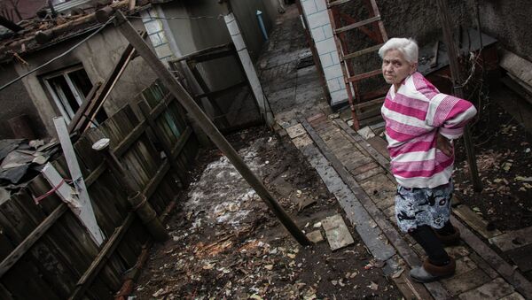 Una anciana delante de su casa destruida por los bombardeos de Donetsk (febrero de 2015) - Sputnik Mundo