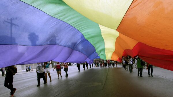 Participants hold a rainbow flag as they march during a Gay Pride Parade in Monterrey May 30, 2015.  - Sputnik Mundo