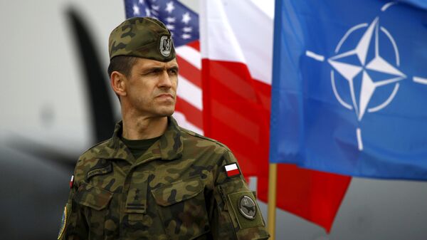Soldado polaco al lado de las banderas de EEUU, Polonia y la OTAN (archivo) - Sputnik Mundo