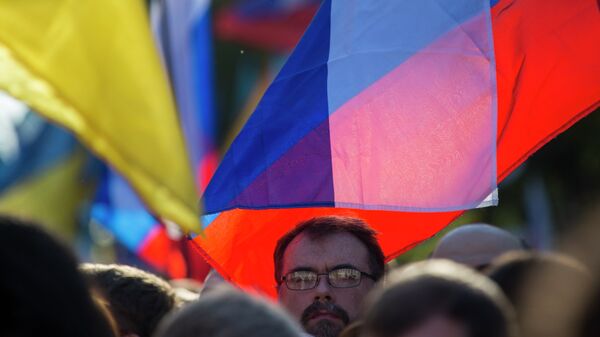 Las personas con banderas de Rusia y Ucrania participan en una manifestación contra la guerra en el centro de Moscú, Rusia. - Sputnik Mundo
