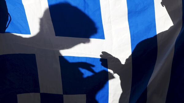 The silhouette of a man using a mobile phone is seen on a Greece flag during a pro-Greece protest in front of the European Union office in Barcelona, Spain, June 29, 2015. - Sputnik Mundo