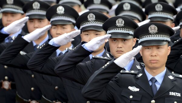 Policemen salute as they march in formation during the opening ceremony of a police sports assembly in Chenzhou, Hunan province, China, June 10, 2015. - Sputnik Mundo