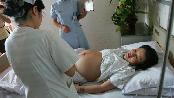 Mujer embarazada en uno de los hospitales en China - Sputnik Mundo