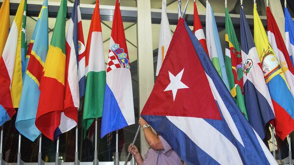 A workman at the US Department of State adds the Cuban flag - Sputnik Mundo