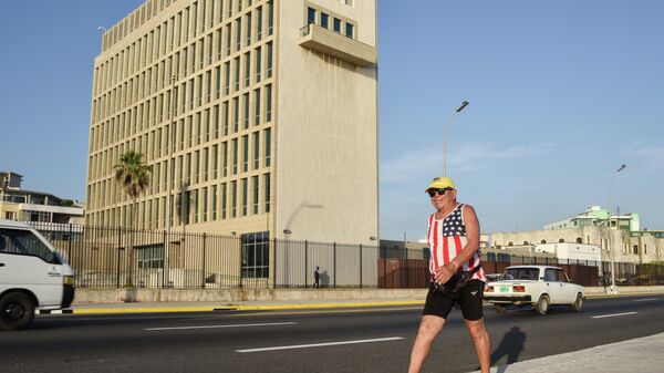 A man wearing a sleeveless shirt with the US flag walks along the Malecon seafront near the US Embassy, on July 20, 2015. T - Sputnik Mundo