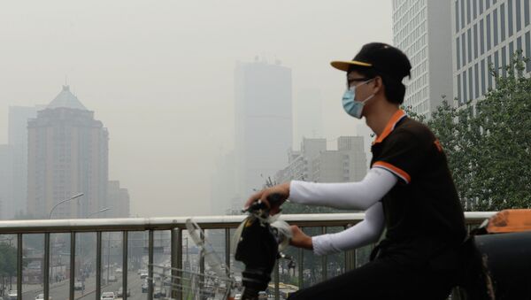 This picture taken on June 23, 2015 shows a cyclist wearing a mask in Beijing covered by heavy smog - Sputnik Mundo