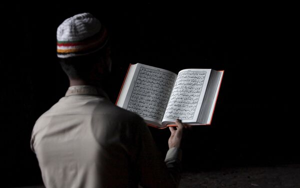 Hombre pakistaní lee el Corán durante la celebración del Ramadán - Sputnik Mundo