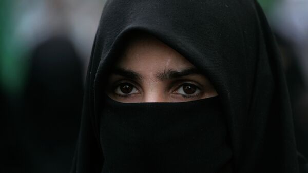 A supporter of Pakistani religious party Jamaat-i-Islami attends a rally to condemn the ban imposed on the burqa or veil in France - Sputnik Mundo