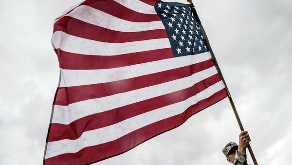 An American Military Cadet holds the U.S flag during his visit in the town of Ferizaj, on June 16, 2015 - Sputnik Mundo