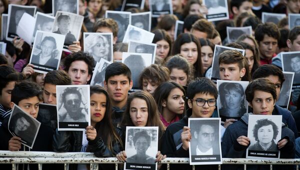 Manifestantes con fotos de victimas de ataque a la AMIA durante un mitin en conmemoración de 21º aniversario de atentado en Buenos Aires, Argentina - Sputnik Mundo