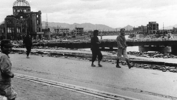 Local residents walk past the gutted Hiroshima Prefectural Industrial Promotion Hall - Sputnik Mundo