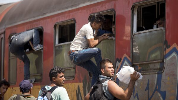 Migrantes abordan un tren en Macedonia - Sputnik Mundo