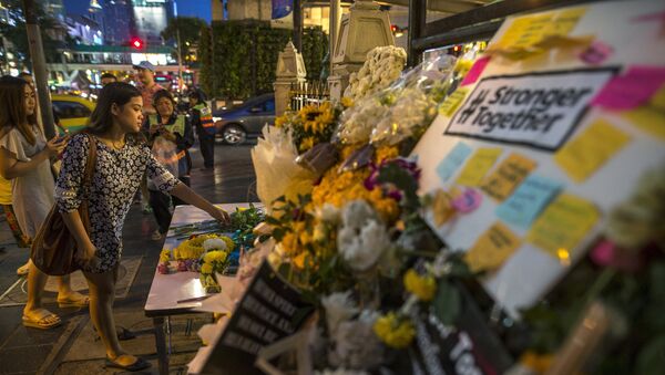 Una mujer pone flores a santuario Erawan donde occurió el atentado este lunes - Sputnik Mundo