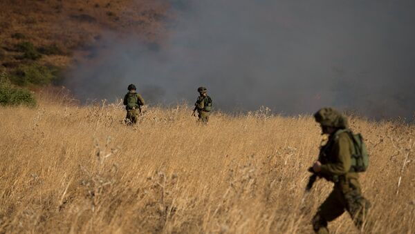 Israeli soldiers patrol next to smoke from a fire caused by a rocket attack in northern Israel, near the Lebanese border - Sputnik Mundo