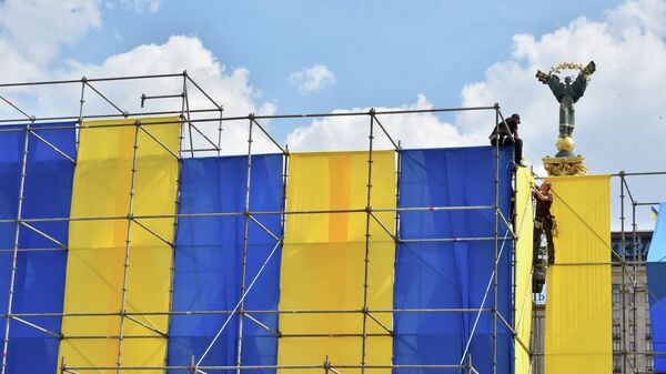 Workers decorate Independece Square with Ukrainian flags during National Flag Day celebrations in Kiev on August 23, 2015. - Sputnik Mundo