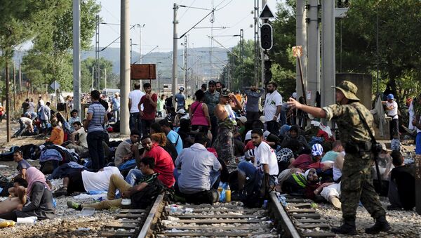 Macedonian special police guard the border as more than a thousand immigrants wait at the border line of Macedonia and Greece to enter Macedonia near the Gevgelija railway station August 20, 2015 - Sputnik Mundo