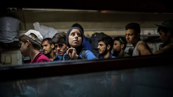 Refugiados se bajan de tren en una estación cerca la frontera con Serbia - Sputnik Mundo