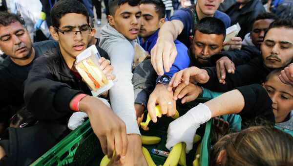 Inmigrantes reciben alimentos mientras hacen cola en la oficina de asuntos sociales de Berlín - Sputnik Mundo