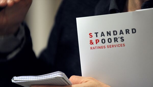A picture shows Ratings agency Standard & Poor's logo on a document in their Paris office prior a yearly press conference about macro economic outlook and general trends on credit markets, focus on credit condition in France and in Europe by sector in Standard & Poor's offices in Paris on December 8, 2011. - Sputnik Mundo