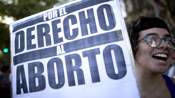 Una mujer con  un banner en Buenos Aires - Sputnik Mundo