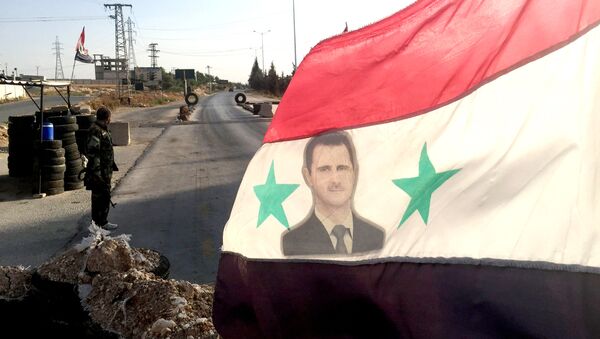 Bandera con una imágen de Bashar Asad - Sputnik Mundo