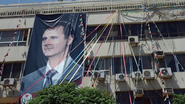 Bandera con una imagen de Bashar Asad - Sputnik Mundo