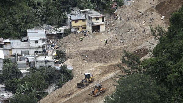 A general view shows heavy machinery and rescue team members working at an area affected by a mudslide in Santa Catarina Pinula, on the outskirts of Guatemala City, October 10, 2015 - Sputnik Mundo