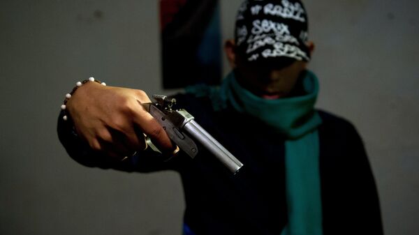 A gang member poses with a homemade gun at the Siloe neighborhood in Cali, Colombia - Sputnik Mundo