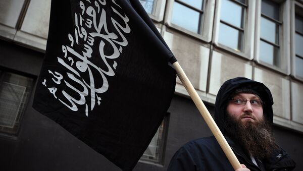Manifestante con una bandera musulmána en Londres - Sputnik Mundo
