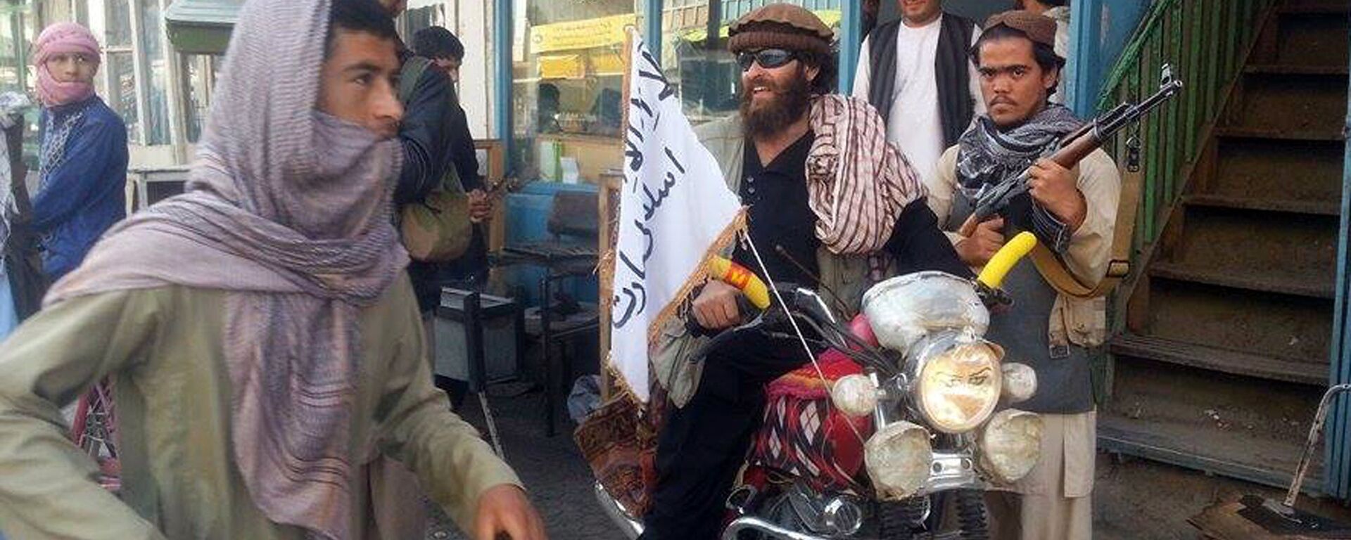 Taliban fighter sits on his motorcycle adorned with a Taliban flag in a street in Kunduz, Afghanistan - Sputnik Mundo, 1920, 13.01.2022