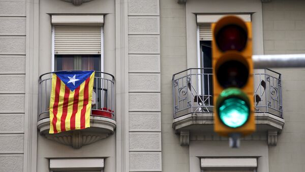 An estelada flag (Catalan separatist flag) hangs from a balcony, next to a green traffic light, in Barcelona, Spain, October 27, 2015 - Sputnik Mundo