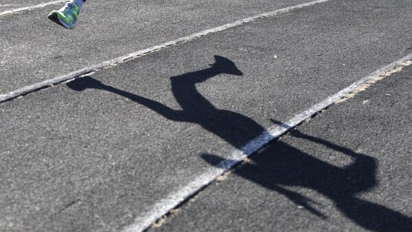 A sportsman casts a shadow on a race track while training at a local stadium in Stavropol - Sputnik Mundo