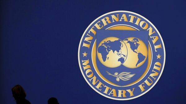Visitors are silhouetted against the logo of the International Monetary Fund at the main venue for the IMF and World Bank annual meeting in Tokyo in this October 10, 2012 - Sputnik Mundo